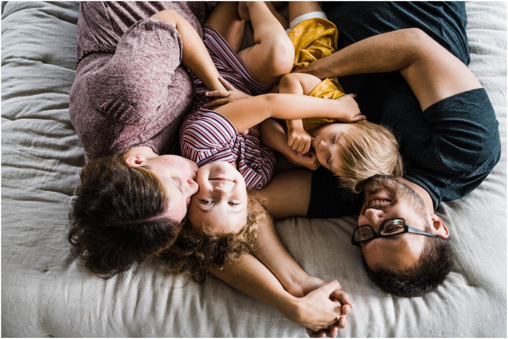 family of 4 pose for family photos at home