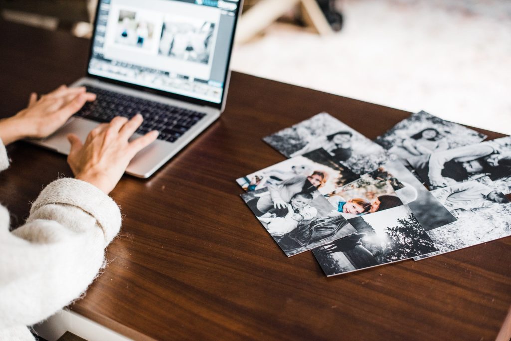 photographer working at desk on print sales to grow photography business