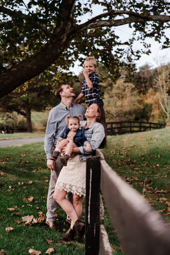 pose with family of four on a fence
