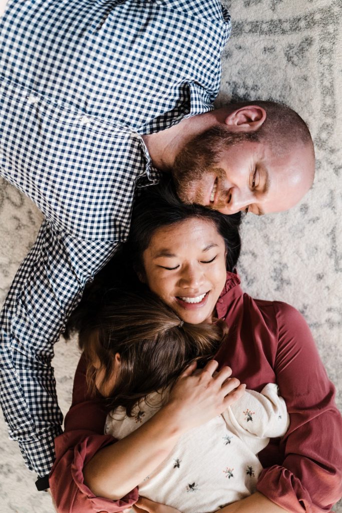 overhead pose of family of three in lifestyle family photos at home