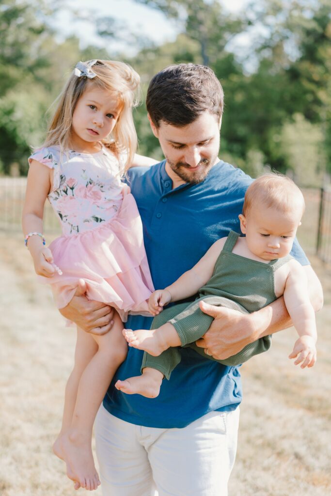 kids with dad pose family photos at home