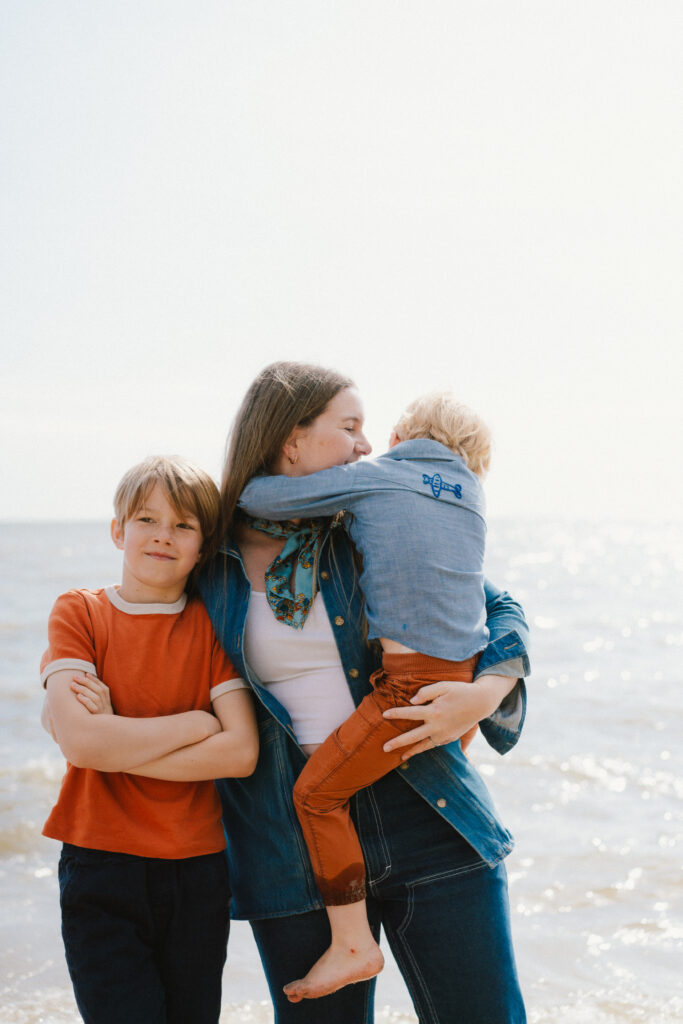 mother with two sons on a beach in family photo session with leah oconnell