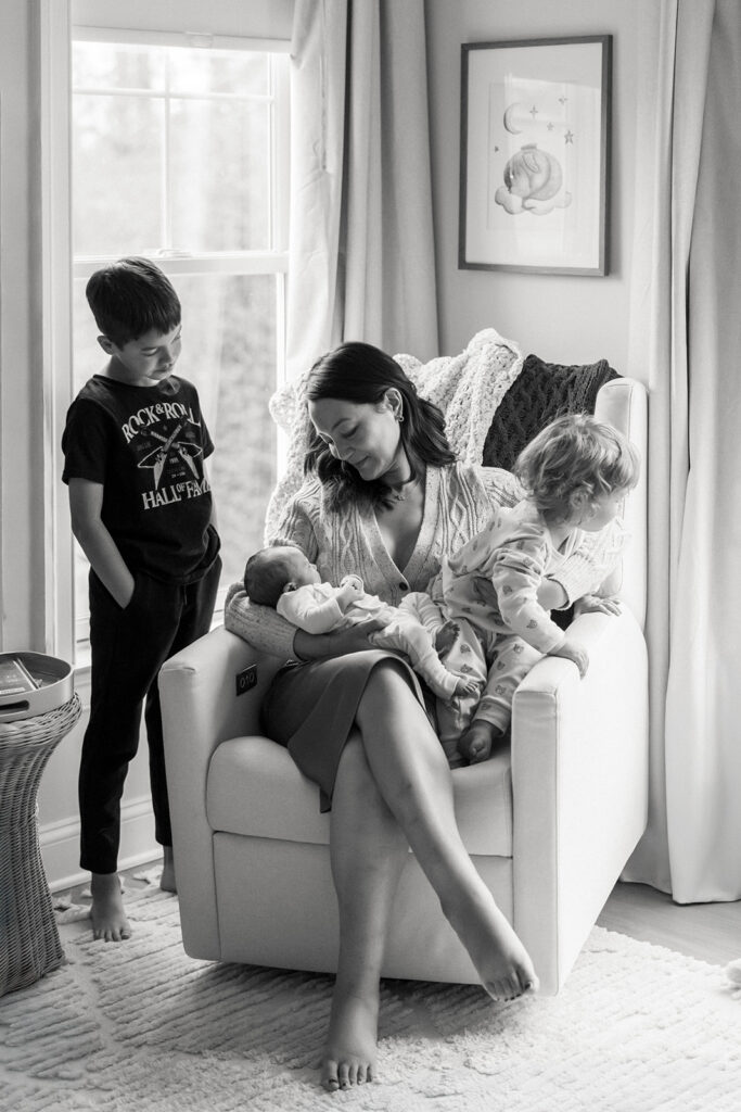 mother in a rocking chair with three boys, lifestyle newborn photos at home