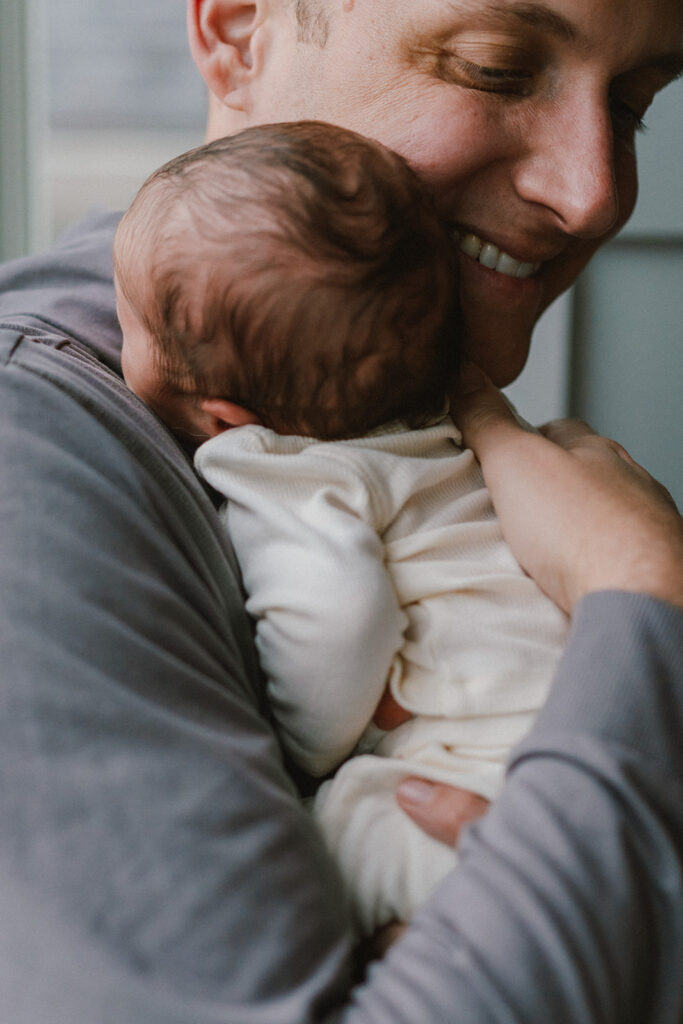 close up photo of dad holding newborn in charlottesville newborn photos