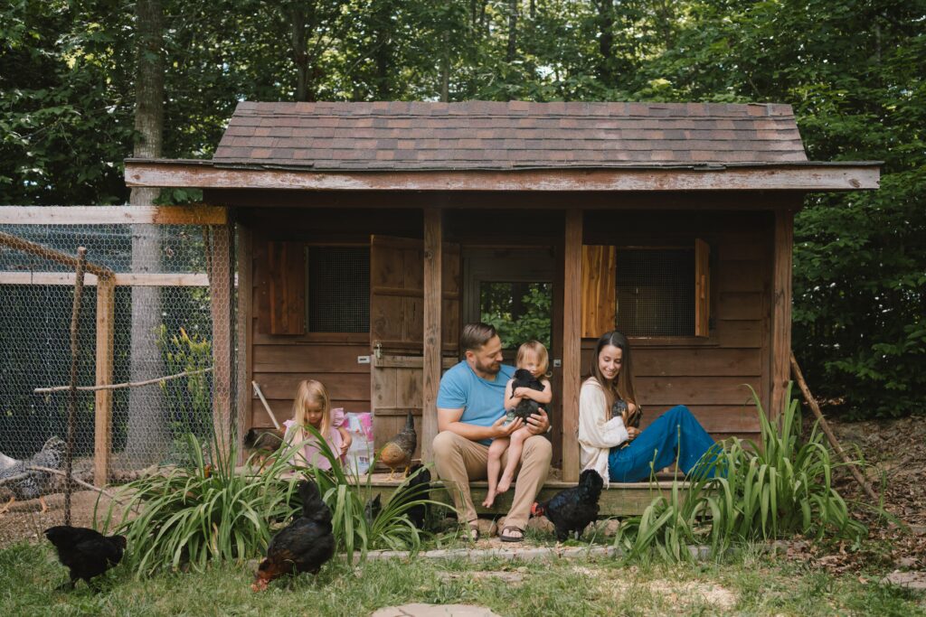 Unposed backyard family photos, sitting by the chicken coup holding chickens in Charlottesville family photo session